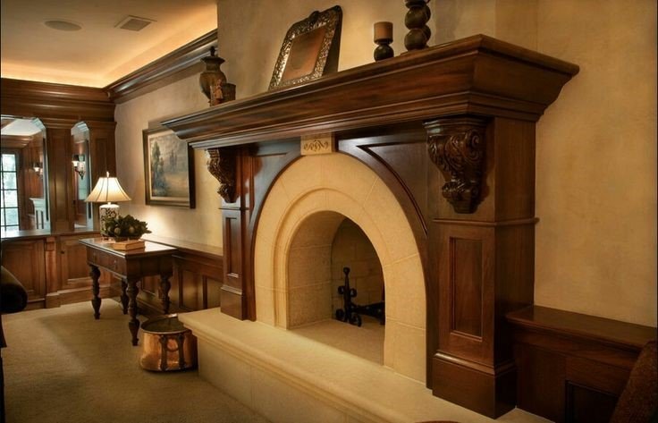 A warm traditional style fireplace in a living room, complemented by woodwork and antique furniture.