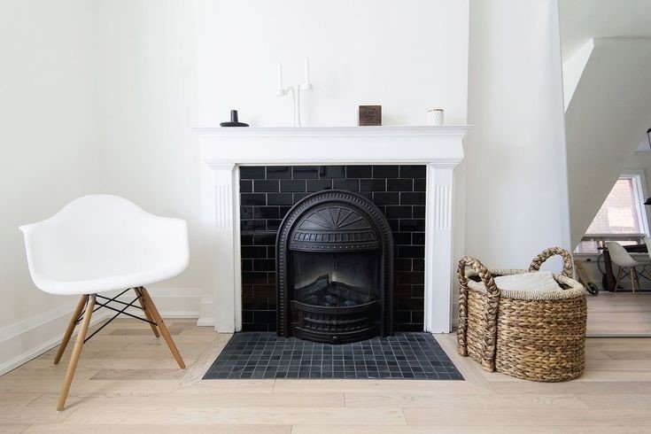 A white fireplace with a black tiles reflecting the clean lines of Scandinavian design in the living room